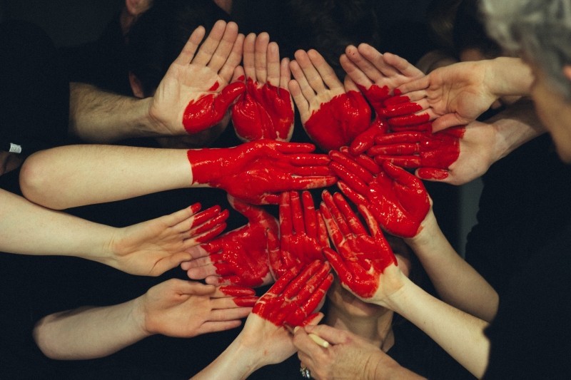 hands coming together all painted in a red heart