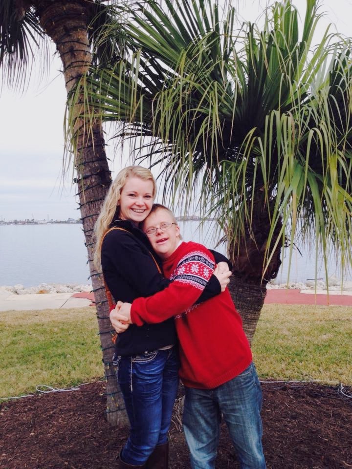 sister hugging brother with down syndrome