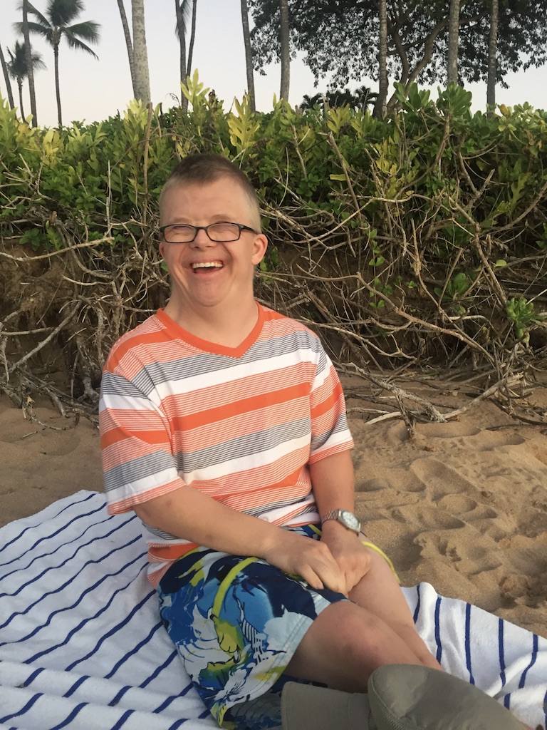 man with down syndrome smiling on the beach