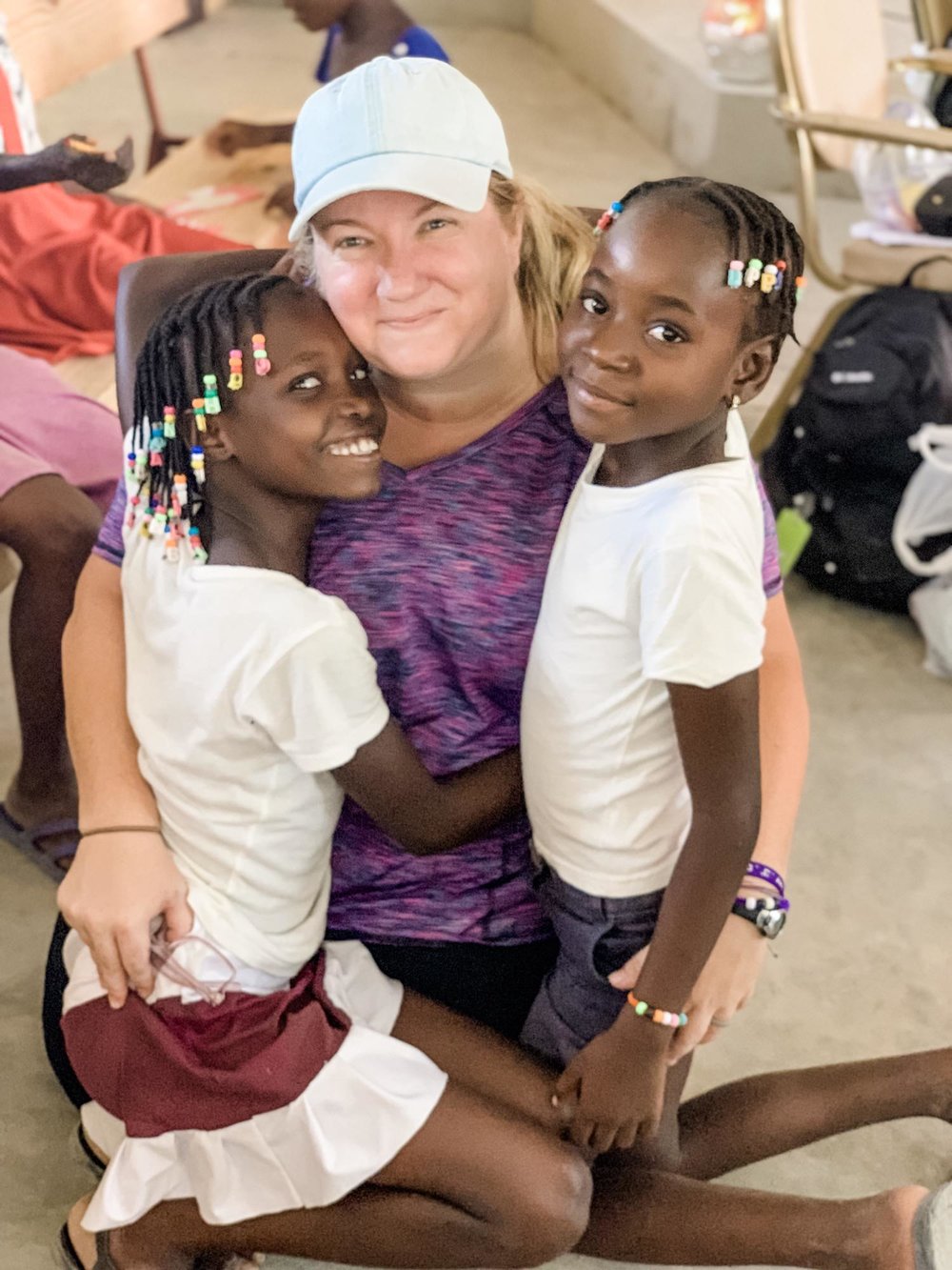 woman smiling with two Haitian girls on each side