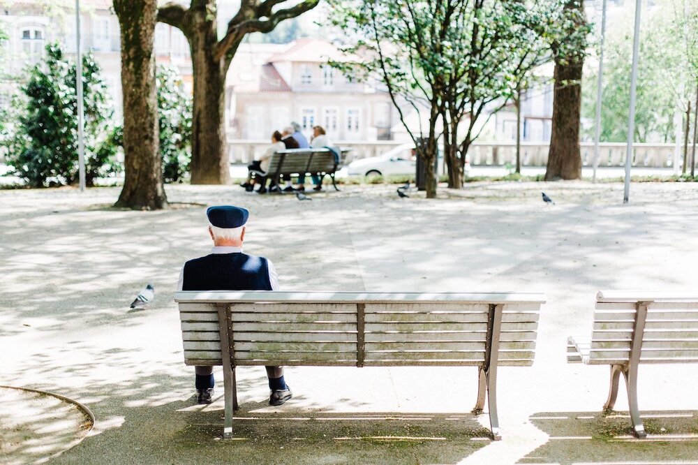 elderly man sitting on park bench alone.jpg